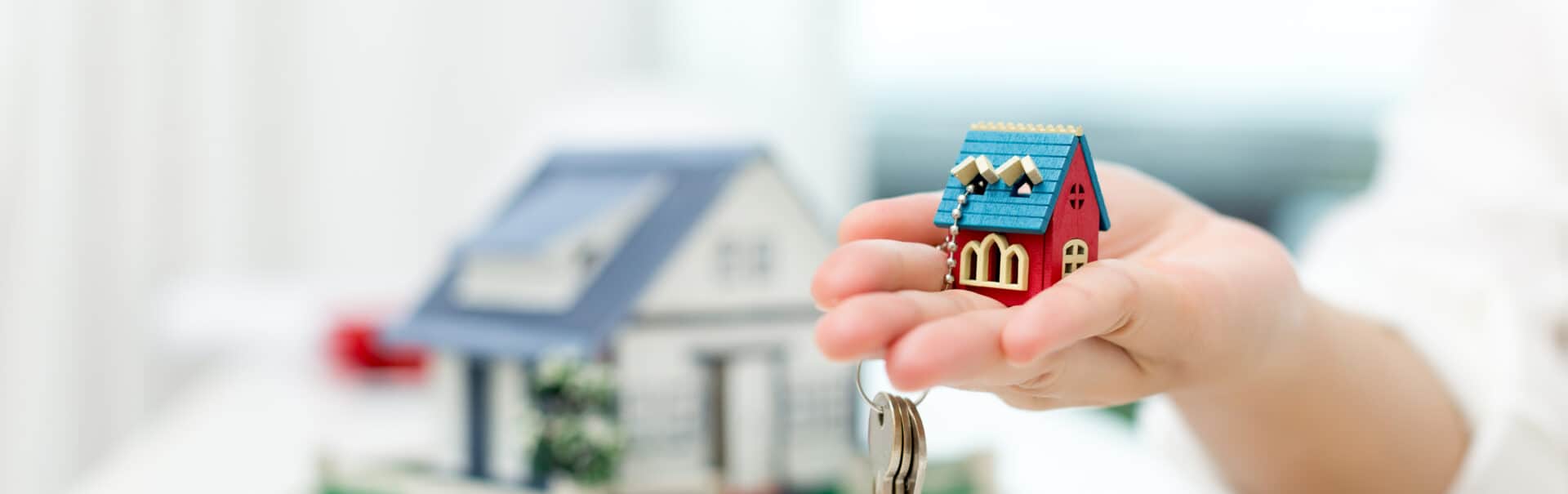 Real Estate Agent With House Model And Keys