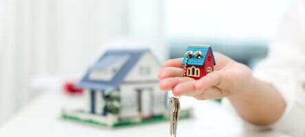 Real Estate Agent With House Model And Keys