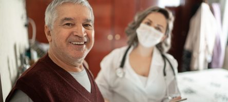 Portrait Of Health Visitor And Senior Man During Home Visit