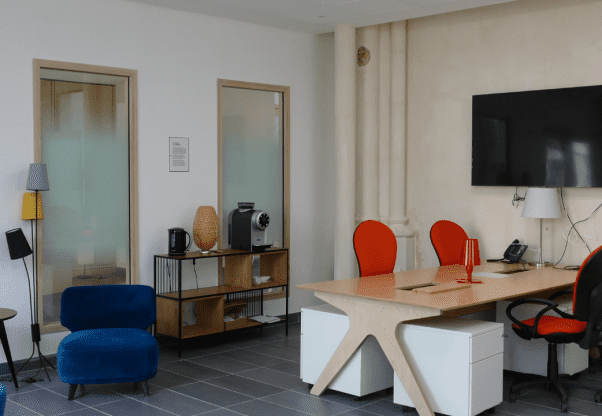 Salle de coworking avec des bureaux, chaises et paperboards