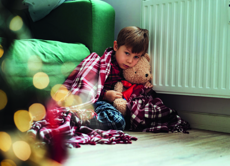 Cute Little Boy Wrapped Id Plaid Sitting By Heater