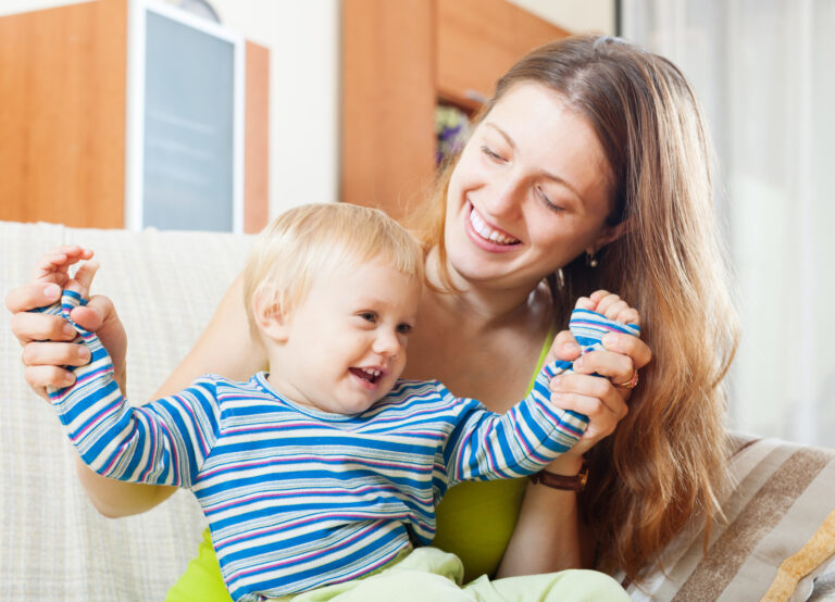 Happy Woman With Toddler On Sofa