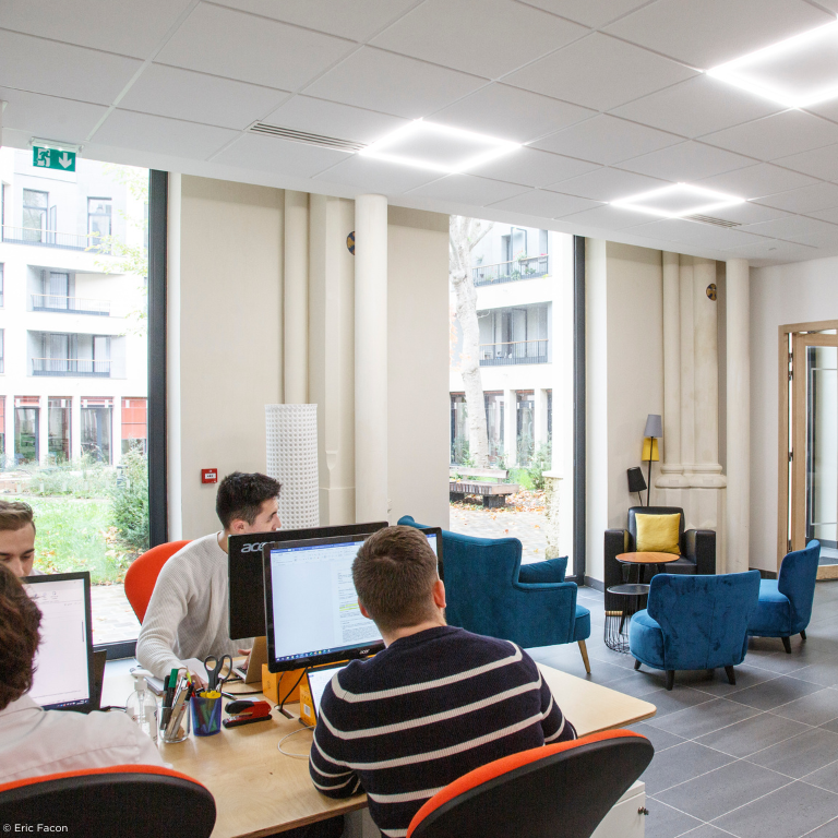 Jeunes personnes devant un écran d'ordinateur dans un espace de coworking