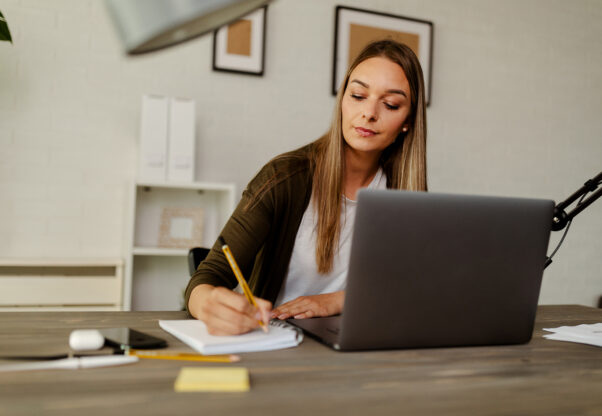 Pensive Female Administrative Assistant Checking Report On Laptop Reading Information, Noting Data.