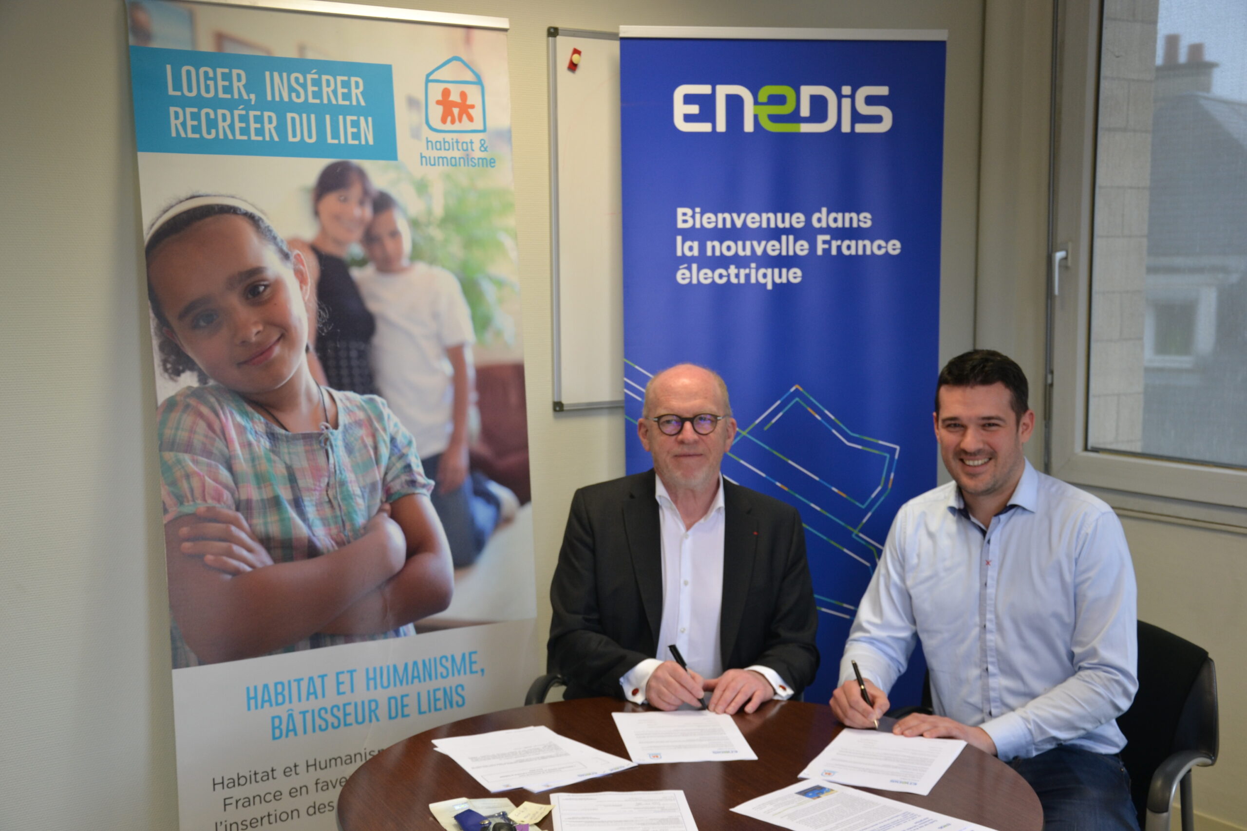 Frédéric Hardouin, Délégué Territorial d'Enedis, et Xavier Onraed, Président d'Habitat et Humanisme Calvados signent ensemble le renouvellement de leur partenariat