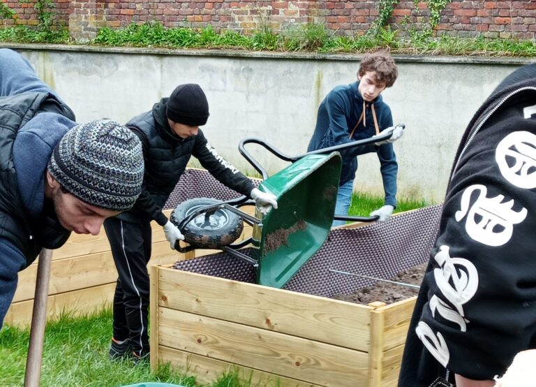 Groupe de jeunes qui renversent de la terre dans les carrés potagers