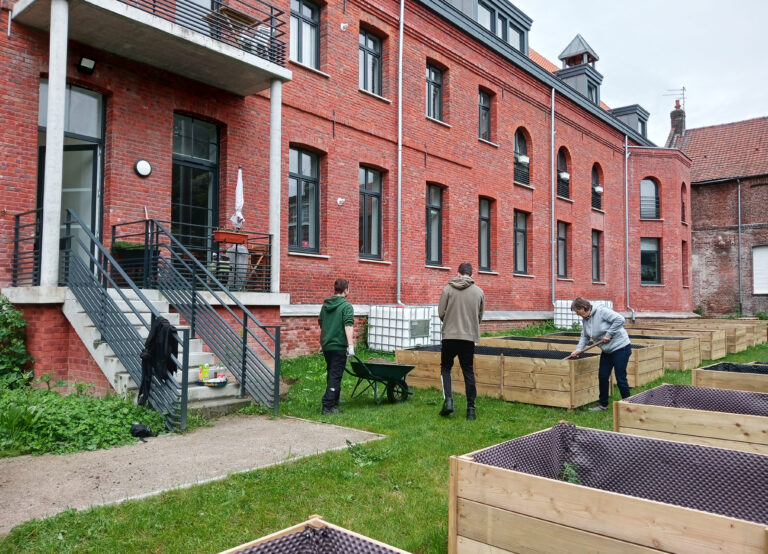 Vue large du jardin de la résidence avec les jeunes qui travaillent