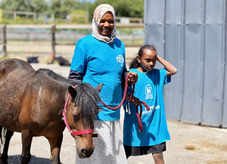 Une mère et sa fille promènent un poney