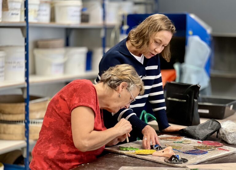 Locataire et animatrice seniors qui peignent des objets en argile